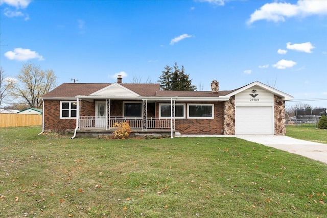 ranch-style home with driveway, an attached garage, covered porch, a front yard, and brick siding