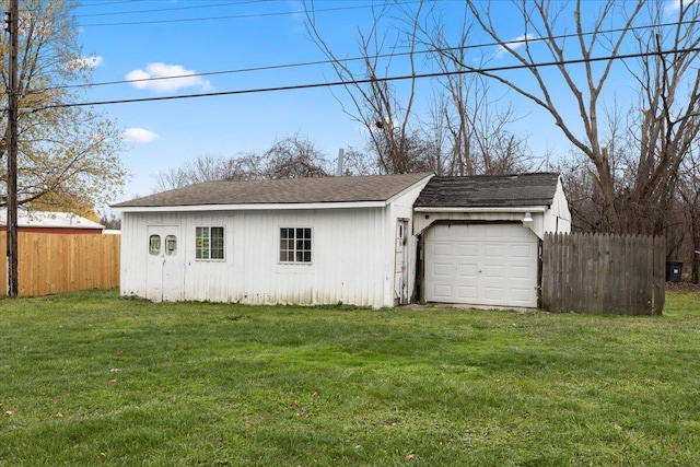 garage featuring driveway and fence