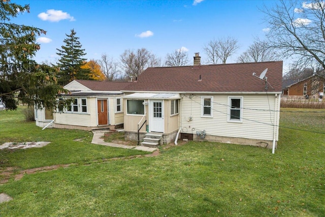 view of front facade with entry steps, roof with shingles, a chimney, and a front lawn