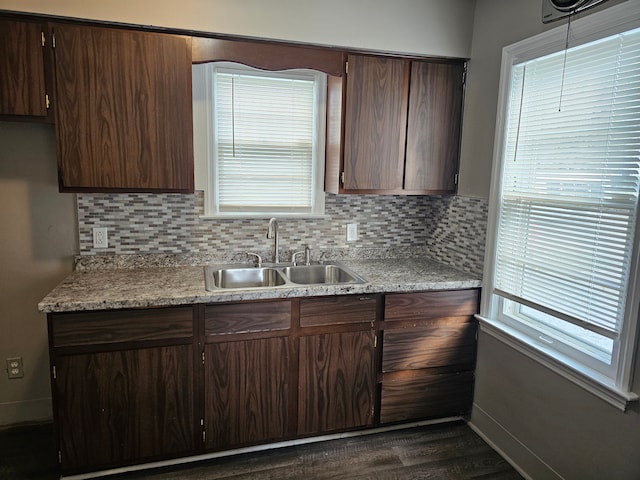 kitchen with decorative backsplash, dark hardwood / wood-style floors, dark brown cabinets, and sink