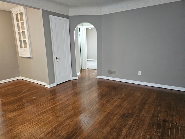 spare room with dark hardwood / wood-style flooring and a textured ceiling