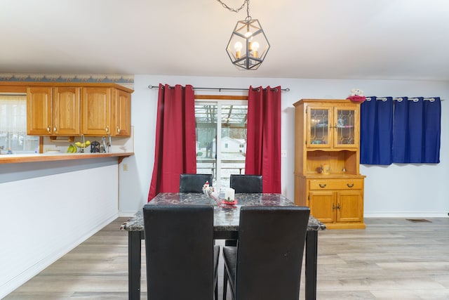 dining area featuring an inviting chandelier and light hardwood / wood-style floors