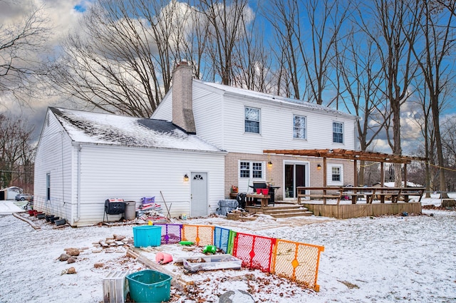 snow covered house featuring a wooden deck