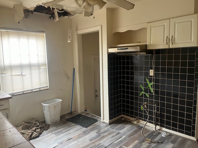 bathroom featuring hardwood / wood-style flooring and tile walls