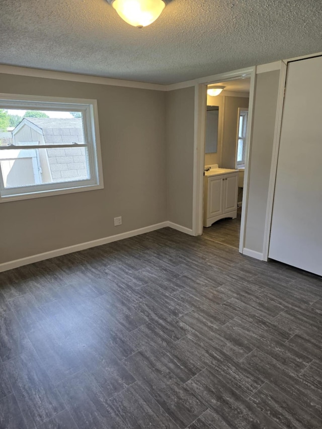 unfurnished room featuring a textured ceiling and dark hardwood / wood-style floors