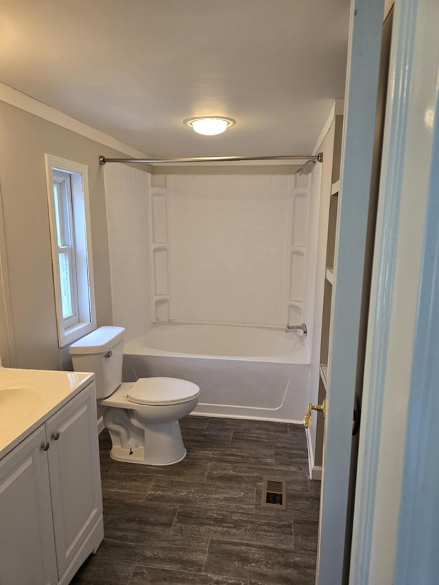 full bathroom with ornamental molding, bathtub / shower combination, vanity, wood-type flooring, and toilet