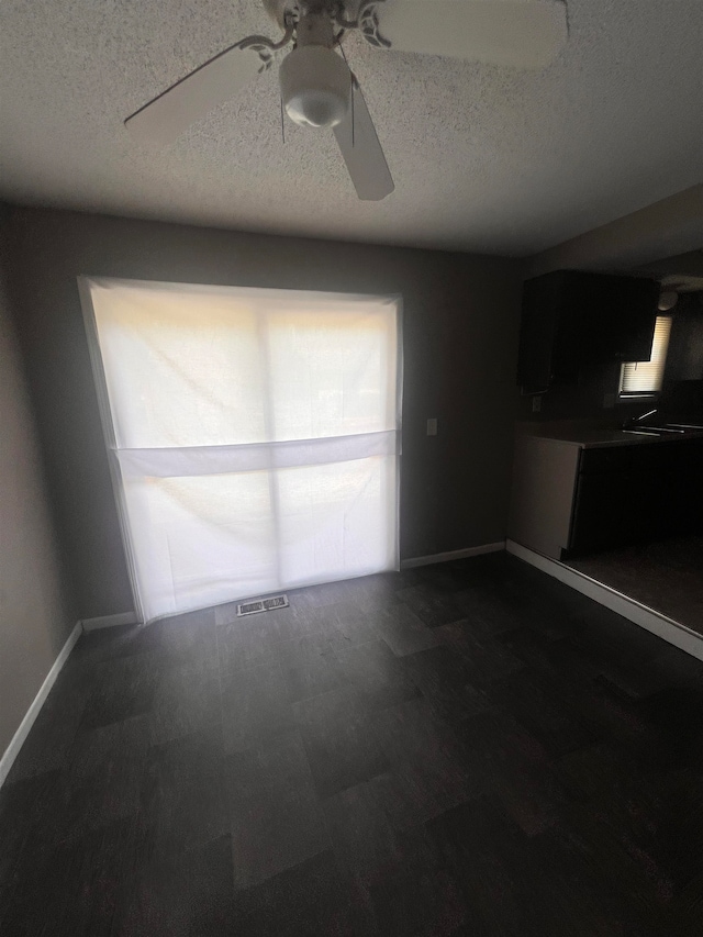 unfurnished room featuring ceiling fan and a textured ceiling