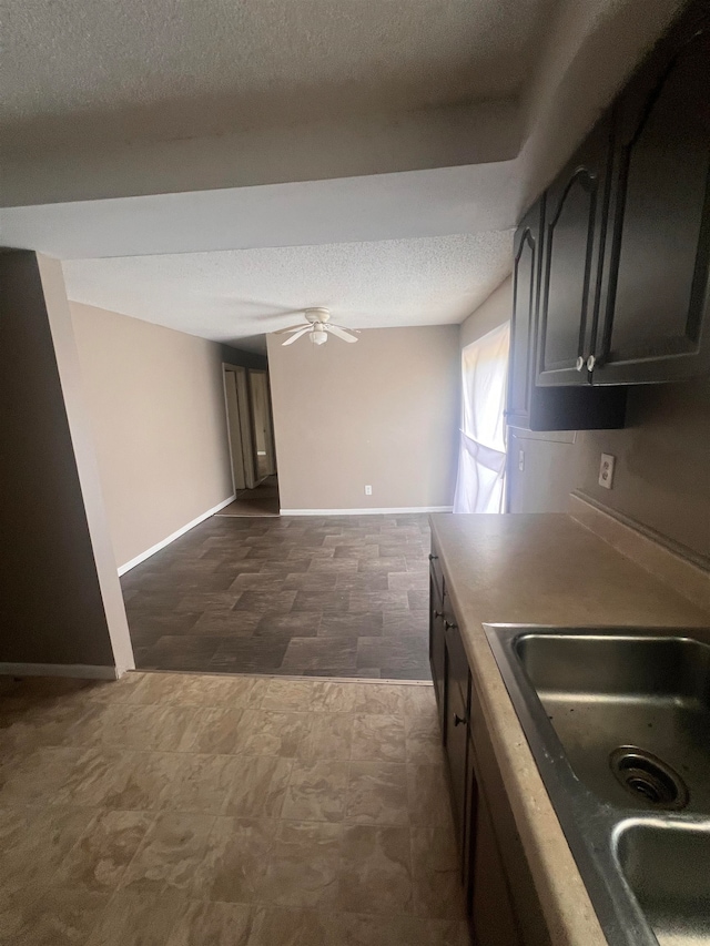 kitchen with ceiling fan, sink, and a textured ceiling