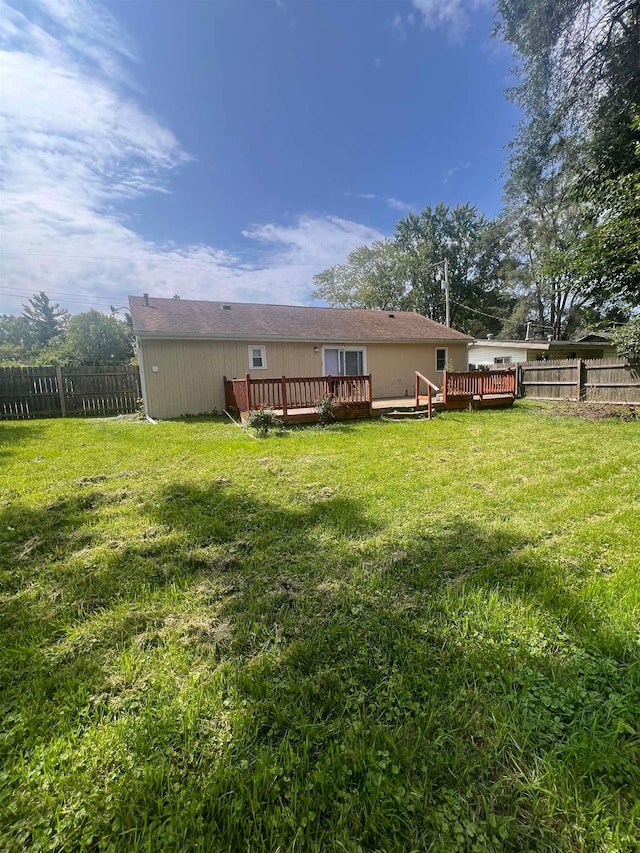 back of property with a yard and a deck