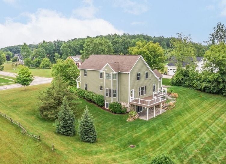 rear view of property with a deck and a yard