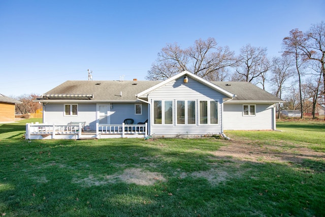 back of property with a deck and a lawn