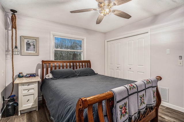 bedroom featuring dark wood-type flooring, a closet, visible vents, and baseboards