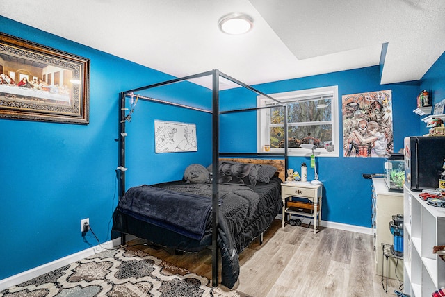 bedroom with wood finished floors and baseboards