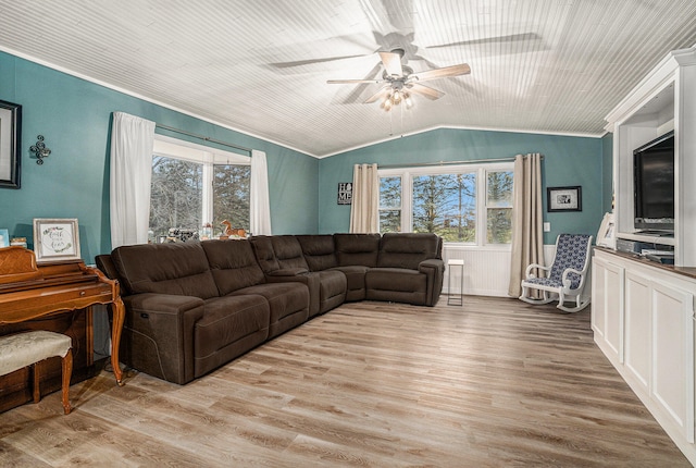 living area featuring light wood-style floors, lofted ceiling, and crown molding