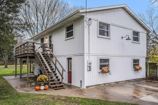 view of side of property with stairs, a patio, and a deck