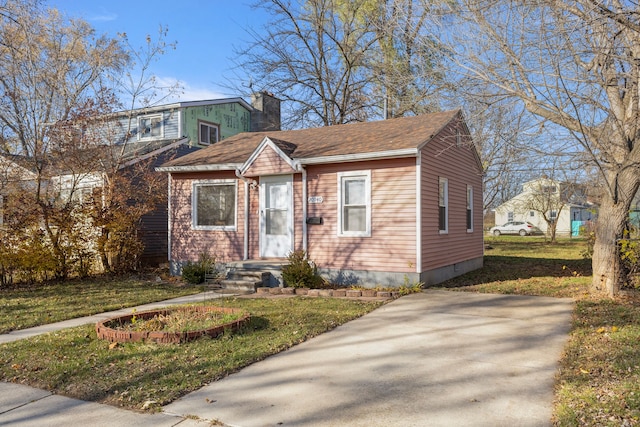 bungalow-style home featuring a front lawn