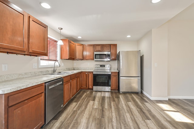 kitchen with decorative light fixtures, dark hardwood / wood-style floors, sink, and appliances with stainless steel finishes