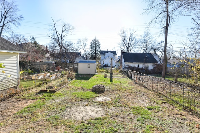 view of yard featuring a storage shed and an outdoor fire pit