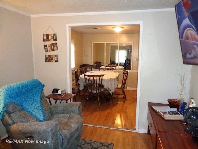 dining area with hardwood / wood-style flooring and crown molding