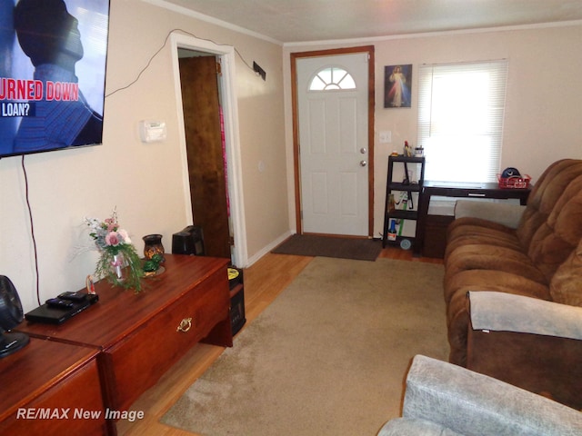 entryway with ornamental molding and light hardwood / wood-style flooring