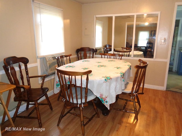 dining space with cooling unit and wood-type flooring