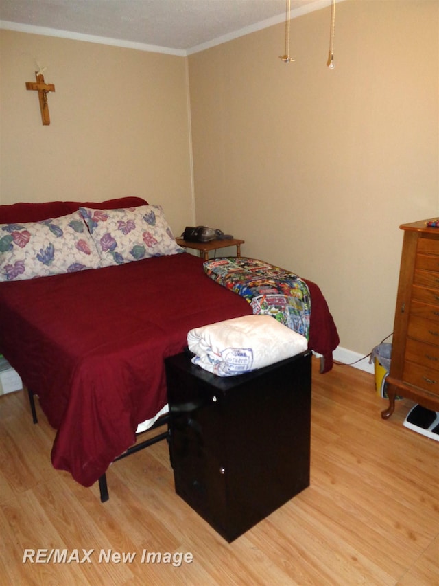 bedroom featuring hardwood / wood-style flooring and crown molding