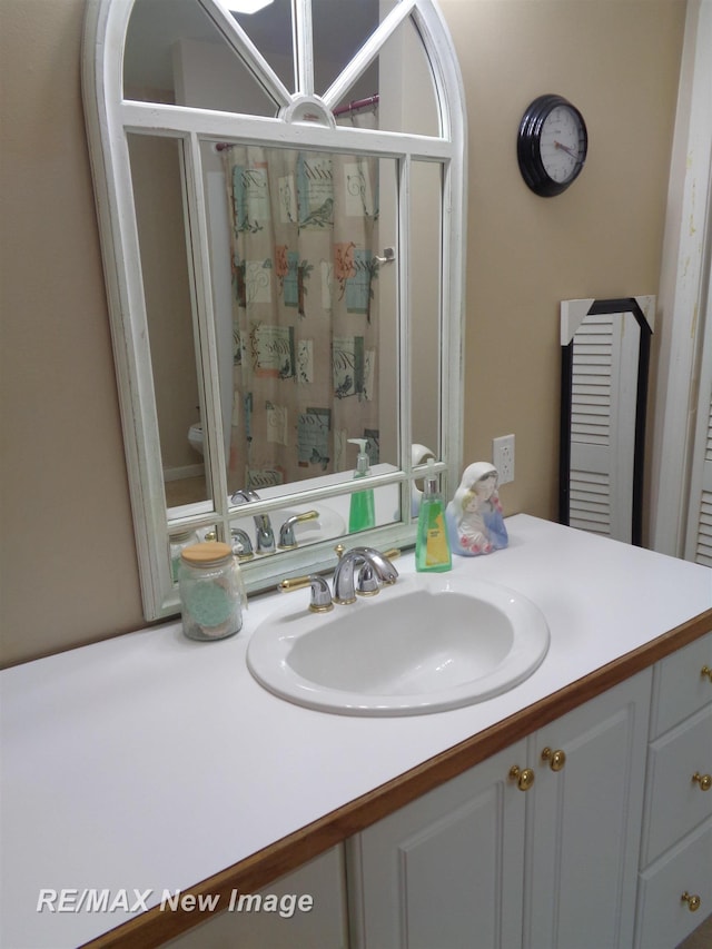 bathroom featuring walk in shower, vanity, and toilet