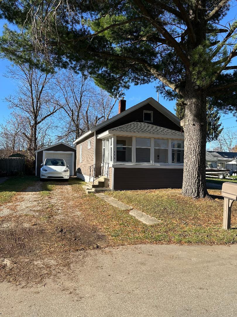 view of front of property with a garage and an outbuilding