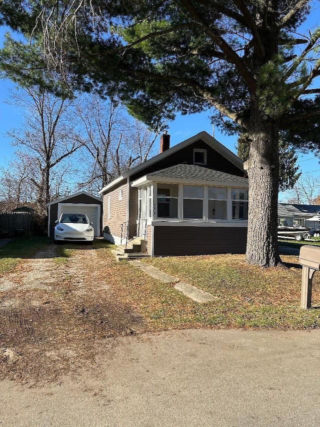 view of front of property with a garage and an outbuilding