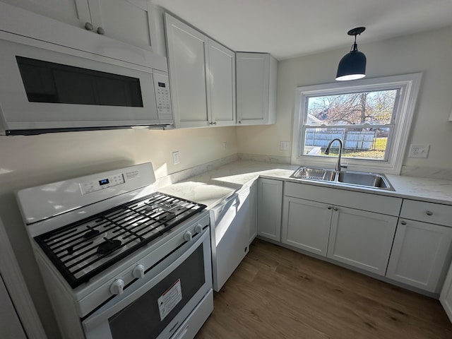 kitchen featuring white cabinets, stainless steel stove, hardwood / wood-style flooring, and sink