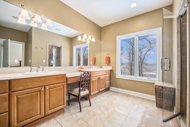 full bath featuring baseboards, double vanity, a sink, an enclosed shower, and a notable chandelier