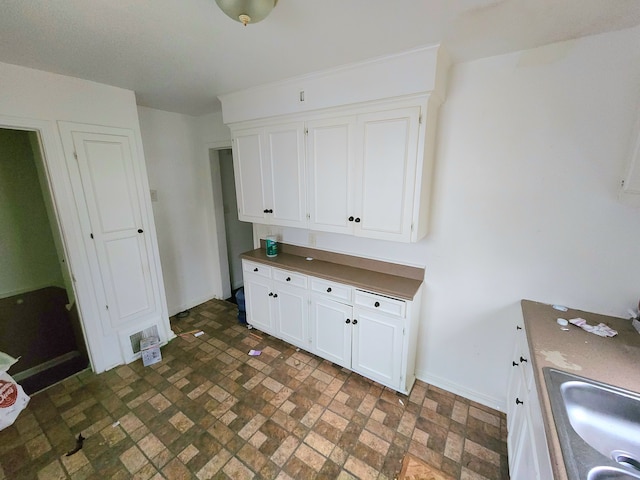 5298 Neff Ave, Detroit, MI 48224 - kitchen featuring brick patterned flooring, white cabinets, and dark countertops