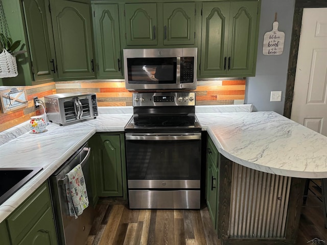 kitchen featuring dark hardwood / wood-style floors, green cabinetry, and appliances with stainless steel finishes