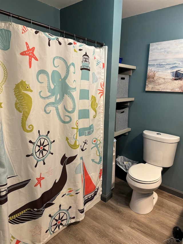 bathroom featuring a shower with curtain, toilet, and hardwood / wood-style flooring