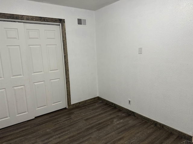 518 W Belle Ave, Saint Charles, MI 48655 - unfurnished bedroom featuring dark wood-type flooring, baseboards, and a closet