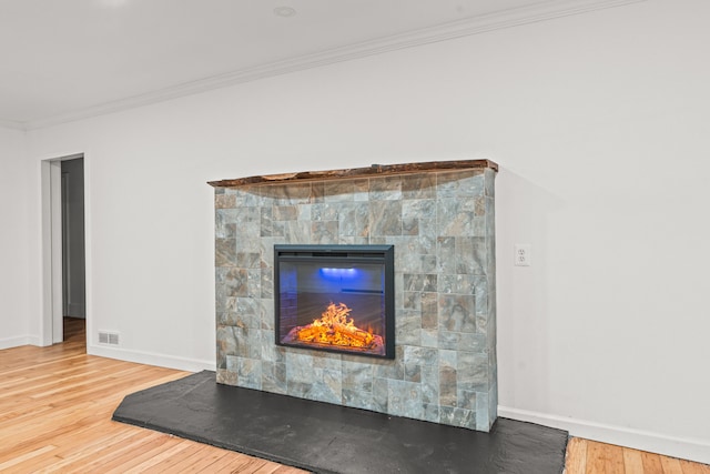 3897 Sand Rd, Port Austin, MI 48467 - detailed view of wood finished floors, ornamental molding, baseboards, and a glass covered fireplace