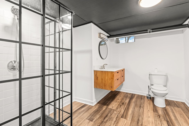 3897 Sand Rd, Port Austin, MI 48467 - full bath with wood finished floors, tiled shower, vanity, baseboards, and toilet