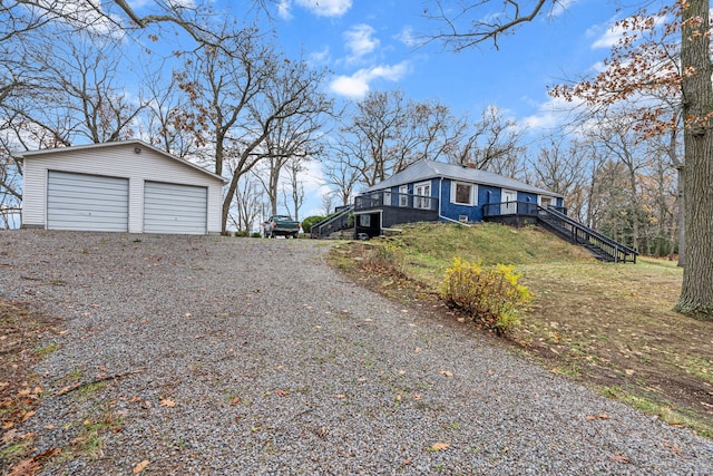 3897 Sand Rd, Port Austin, MI 48467 - view of side of property with stairs, an outdoor structure, a detached garage, and driveway