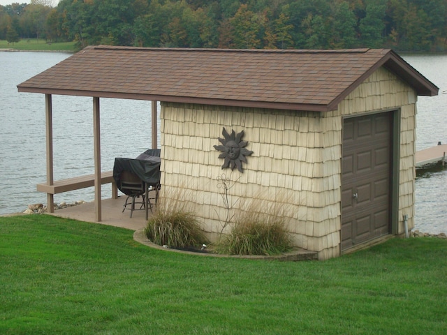 view of outbuilding with a yard and a water view