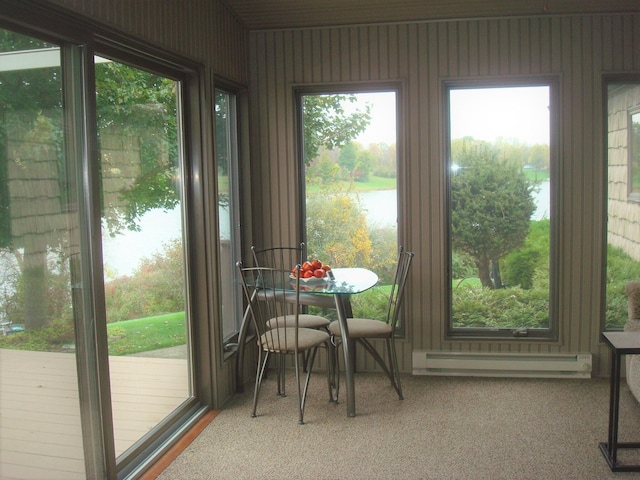 sunroom / solarium featuring a water view and a baseboard heating unit