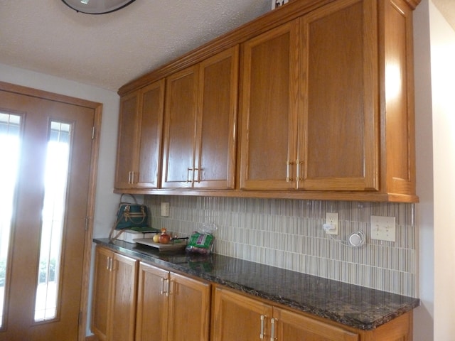 kitchen with decorative backsplash and dark stone counters