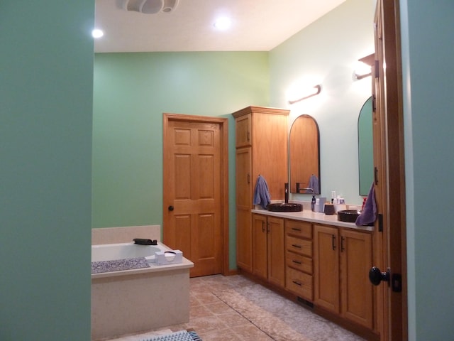 bathroom featuring tile patterned flooring, vanity, and a tub to relax in