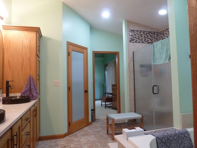 bathroom with tile patterned flooring, vanity, vaulted ceiling, and independent shower and bath