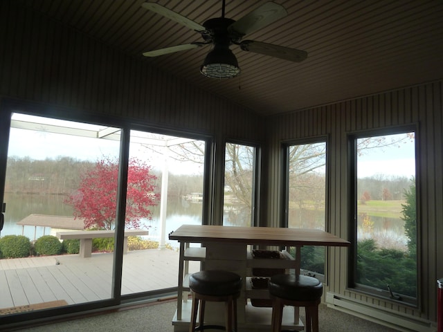 sunroom with ceiling fan, a water view, and a baseboard radiator