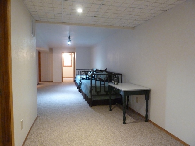 bedroom with a paneled ceiling and light colored carpet