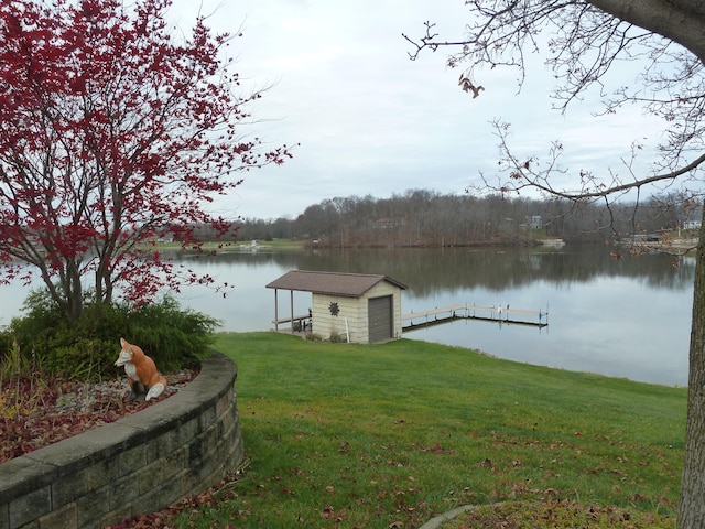 dock area with a lawn and a water view