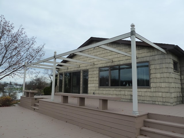 view of property exterior with a deck with water view