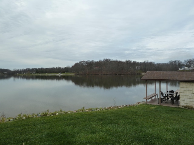 view of dock featuring a lawn, a water view, and a patio