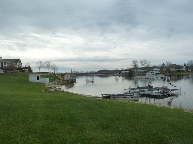 view of dock featuring a lawn and a water view