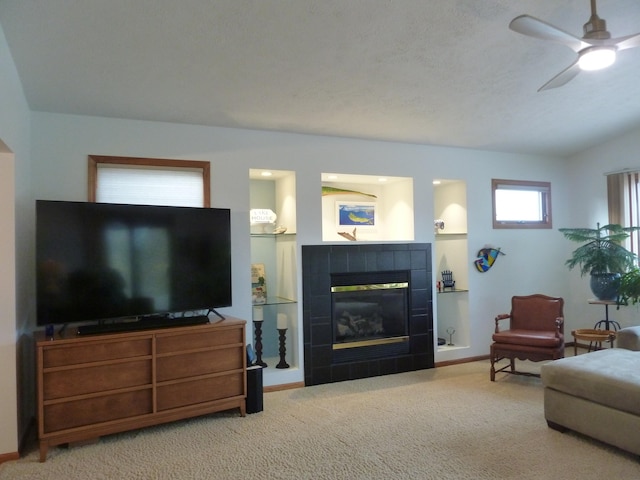 living room with ceiling fan, carpet floors, a fireplace, and lofted ceiling